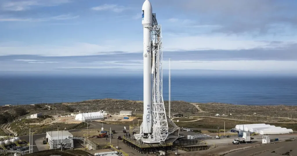 A SpaceX rocket stands ready for launch at a coastal launch site.