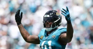A Jacksonville Jaguars football player celebrates with his hands raised during a game.