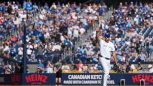 A baseball player in a Toronto Blue Jays uniform waves to the crowd during a game.