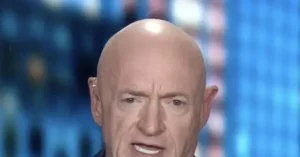 The image shows a close-up of a bald individual with a serious expression, set against a blurred background with blue tones.