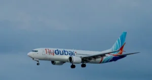 A flydubai aircraft is captured in flight against a clear sky.