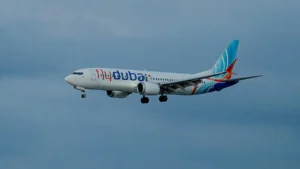 A flydubai aircraft is captured in flight against a clear sky.