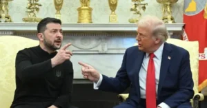 The photo shows two individuals engaged in a conversation, with one pointing while the other listens attentively.