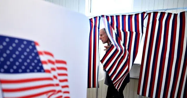 A man is seen inside a voting booth with an American flag in the background, symbolizing the voting process in the United States.