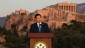A man stands at a podium with the Department of State seal, delivering a speech in front of the Acropolis in Athens, Greece.