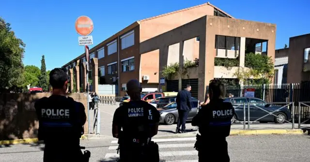 Police officers are seen standing near a building with a "SAUF VEHICULES AUTORISES" sign, indicating restricted access for unauthorized vehicles.