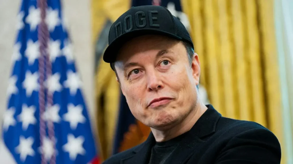 The image shows a person wearing a "DOGE" cap in a setting with an American flag in the background.