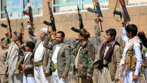 A group of individuals, some in military attire, raise their weapons in a public demonstration.