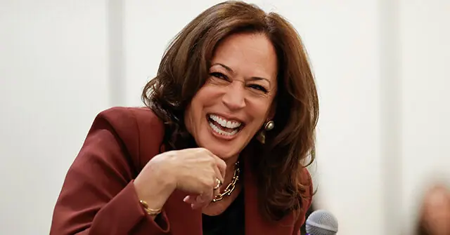 The image shows a person in a professional setting, smiling and gesturing with their hand, suggesting a moment of engagement or communication.