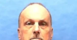 The image shows a close-up of a person's face against a blue background.