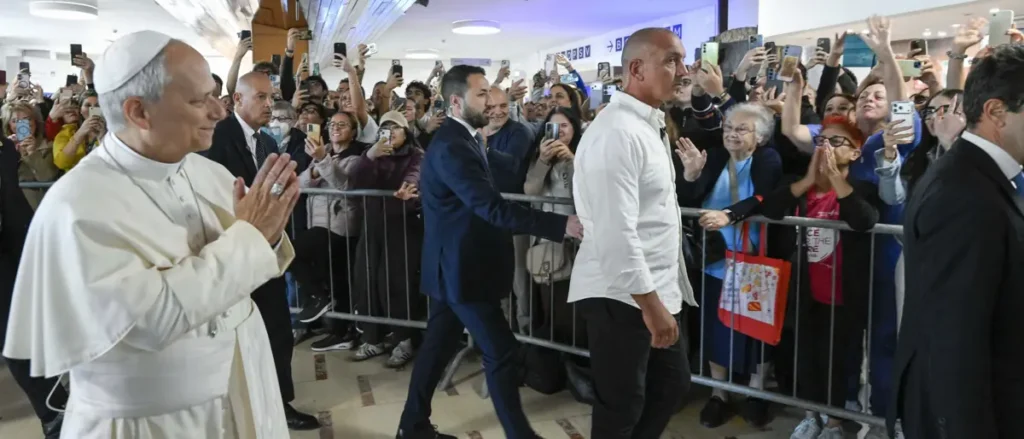 Pope Francis greets a crowd of enthusiastic supporters as he arrives at an event.