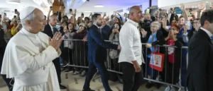 Pope Francis greets a crowd of enthusiastic supporters as he arrives at an event.