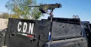 The image shows a heavily armored vehicle with the letters "C.D.N." and a mounted machine gun, indicating it may be used for security or military purposes.
