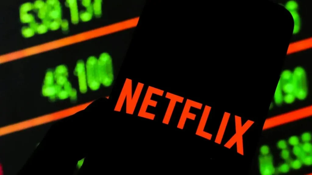 The image shows a silhouette of a Netflix logo against a backdrop of stock market numbers, suggesting a discussion about Netflix's financial performance or stock market activity.