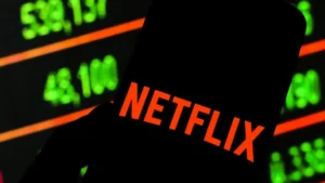 The image shows a silhouette of a Netflix logo against a backdrop of stock market numbers, suggesting a discussion about Netflix's financial performance or stock market activity.