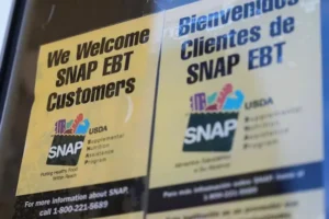 The photo shows signs welcoming SNAP EBT customers, indicating the Supplemental Nutrition Assistance Program, in both English and Spanish.