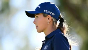The image shows a golfer wearing a blue cap and uniform, looking focused and ready for a game.