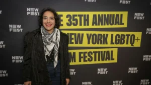 A person is smiling at the camera at the 35th Annual New York LGBTQ+ Film Festival.