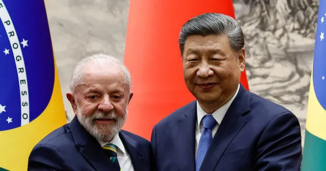 The photo shows two leaders standing in front of their respective national flags, indicating a diplomatic or official meeting.