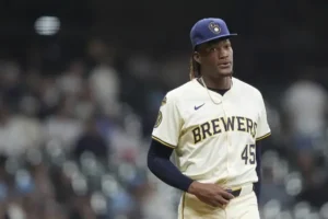 The image shows a baseball player wearing a Milwaukee Brewers uniform, standing on the field during a game.