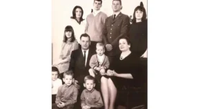 This is a vintage family portrait featuring adults and children dressed in formal attire, likely from the mid-20th century.