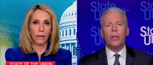 The image shows two individuals participating in a "State of the Union" broadcast, with one person on the left wearing a blue outfit and the other on the right in a suit, set against a backdrop featuring the Capitol building.