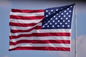 The American flag waves proudly against a clear sky.