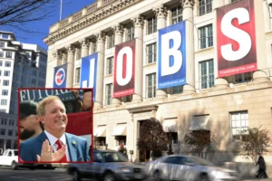 The image shows a large building with "JOBS" banners displayed on its facade, alongside a smaller inset photo of a man in a suit clapping.