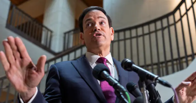A man in a suit and tie is speaking at a press conference, gesturing with his hands.