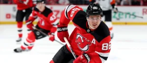 A hockey player in a red and black jersey, number 86, is in action on the ice during a game.