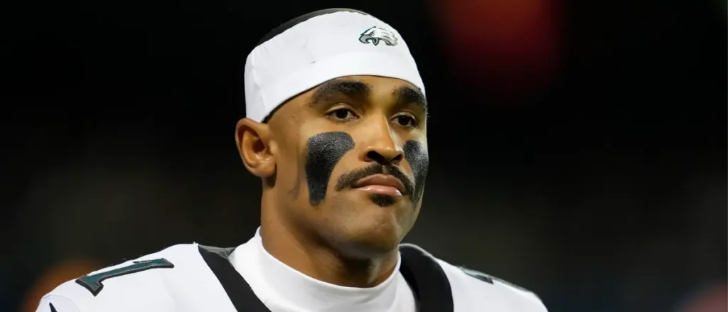 The image shows a football player wearing a Philadelphia Eagles uniform and headband, with black face paint on his cheeks.