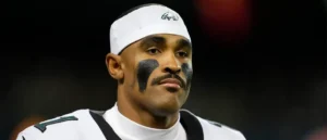 The image shows a football player wearing a Philadelphia Eagles uniform and headband, with black face paint on his cheeks.