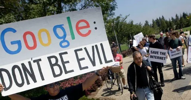 A group of protesters holds signs calling for Google to "Don't Be Evil" and to "Save the Internet."