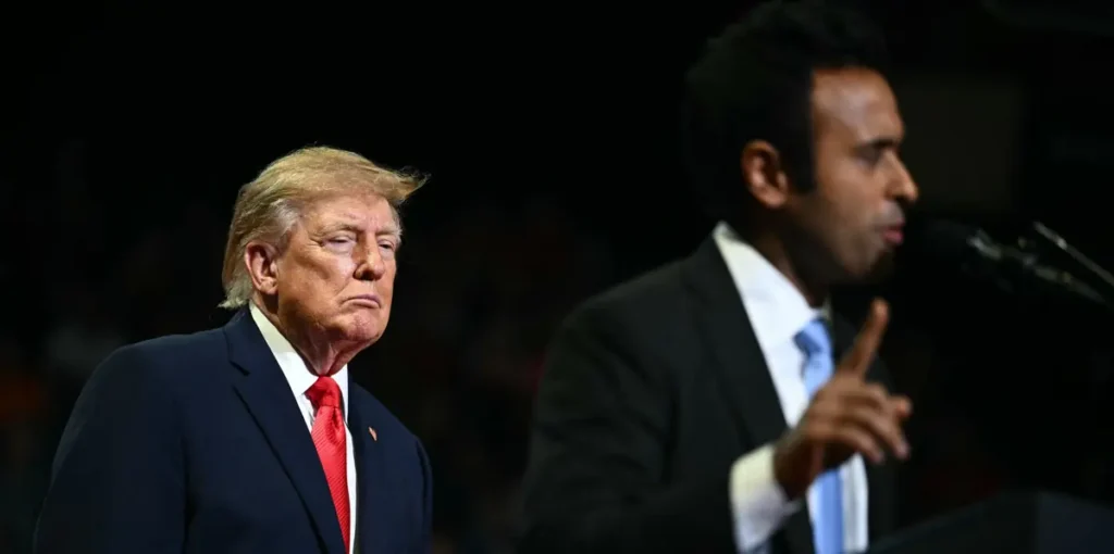 The image shows two individuals, one in a suit with a red tie and another in a suit with a blue tie, standing at a podium, likely during a political event or debate.