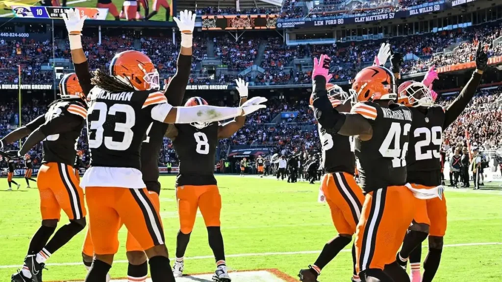 A group of Cleveland Browns players celebrate on the field during a football game.