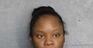 The image appears to be a mugshot of a person with short, dark hair against a plain background.