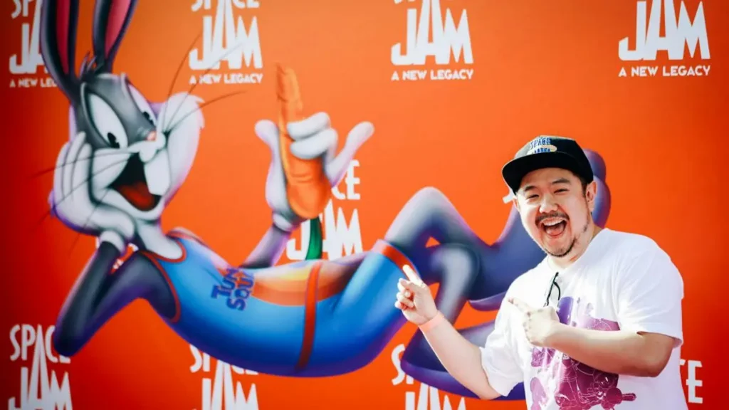 A person poses in front of a "Space Jam: A New Legacy" backdrop featuring Bugs Bunny.