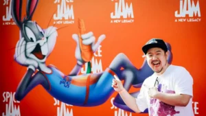 A person poses in front of a "Space Jam: A New Legacy" backdrop featuring Bugs Bunny.