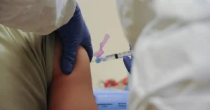 A healthcare worker administers a vaccine to a patient in a clinical setting.
