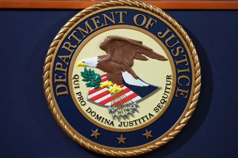 The image shows the seal of the Department of Justice, featuring an eagle, an olive branch, and the Latin phrase "Qui pro domina justitia sequitur."