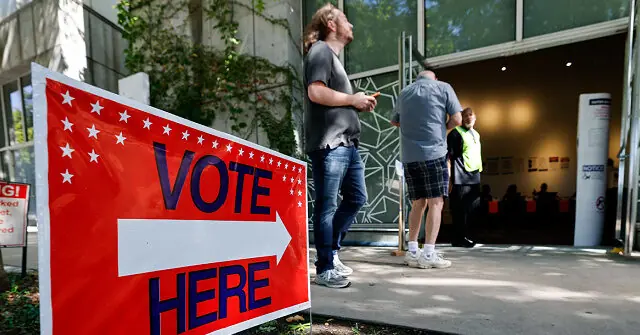 A "Vote Here" sign directs people to a polling station where individuals are seen entering and exiting.
