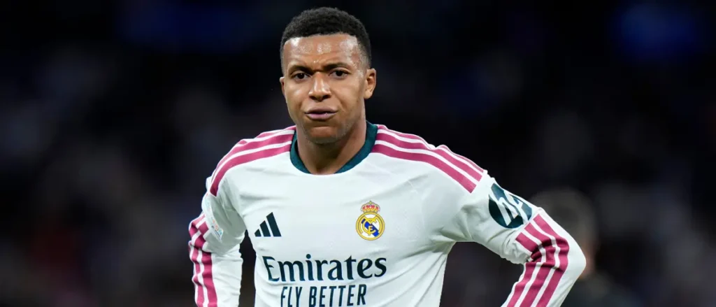 The image shows a football player wearing a Real Madrid jersey with the Emirates logo and the slogan "Fly Better."
