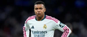 The image shows a football player wearing a Real Madrid jersey with the Emirates logo and the slogan "Fly Better."