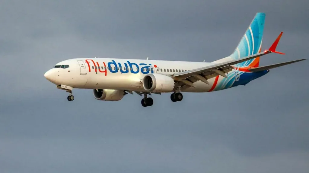 A flydubai aircraft is captured in flight against a cloudy sky.