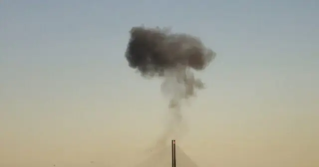 A large plume of smoke rises into the sky, indicating a significant event or incident.