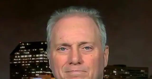 The image shows a close-up of a person with a cityscape in the background, featuring illuminated buildings at night.