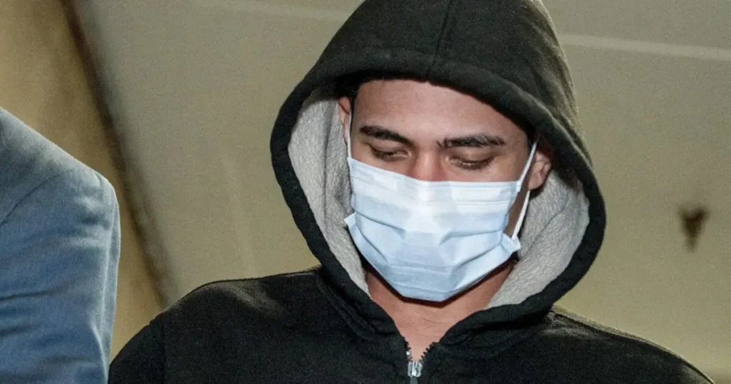 A person wearing a hooded jacket and a face mask is seen in this news photo.