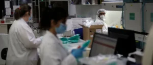 Scientists in protective gear work in a laboratory setting, emphasizing the importance of safety and hygiene in research environments.