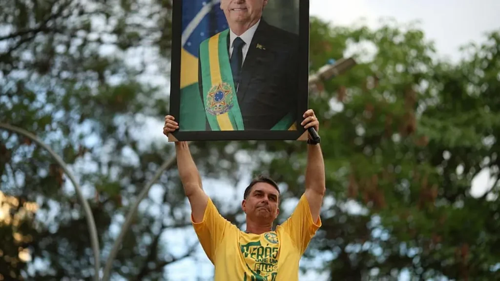 A man holds up a portrait of a Brazilian president wearing the presidential sash, symbolizing support for the government.
