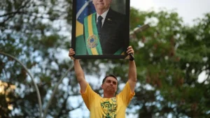 A man holds up a portrait of a Brazilian president wearing the presidential sash, symbolizing support for the government.